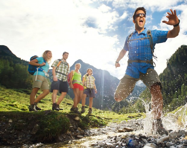 Sprung über kleinen Gebirgsbach beim Wandern © Flachau Tourismus